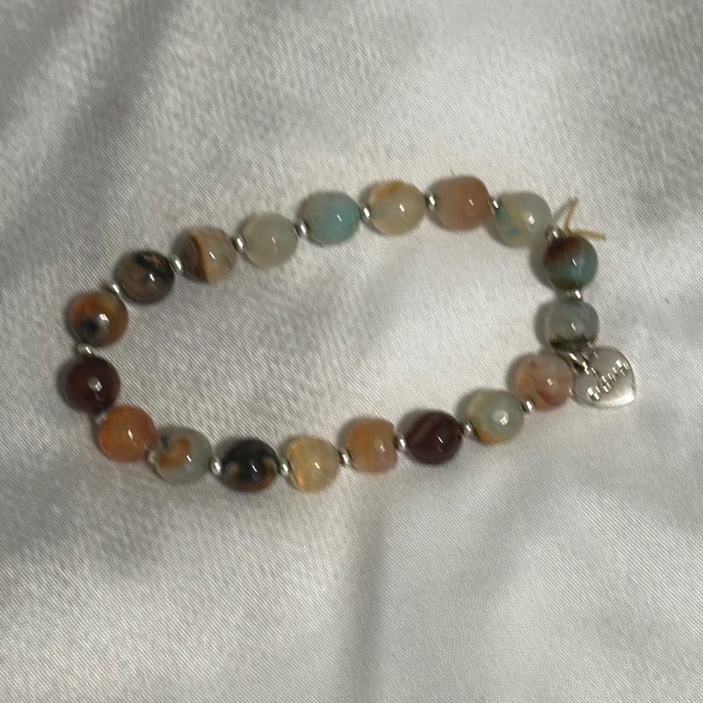 Natural stone multi gem bracelet with silver spacers and a silver heart charm.